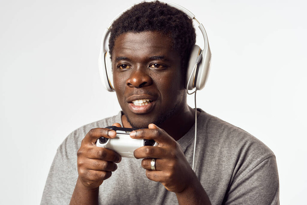 человек африканский внешний вид с геймпадом в руках, играя в развлекательные технологии - Фото, изображение