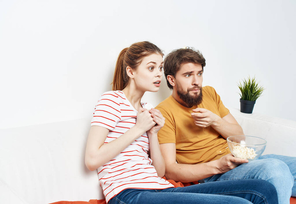 hauska mies ja nainen kotona sohvalla hauskaa levätä popcorn - Valokuva, kuva