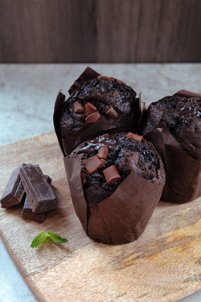 three freshly made muffins with chocolate chips on top - Foto, afbeelding