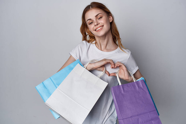 woman with multicolored shopping bags Shopaholic lifestyle light background - Photo, Image