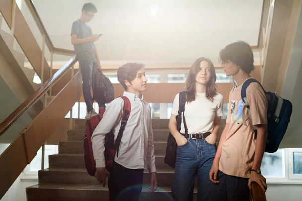 Σχολικοί φίλοι που μιλούσαν στις σκάλες του σχολείου κατά τη διάρκεια του διαλείμματος - Φωτογραφία, εικόνα