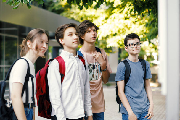 Koulukaverit katselevat aikataulua koulun edessä - Valokuva, kuva