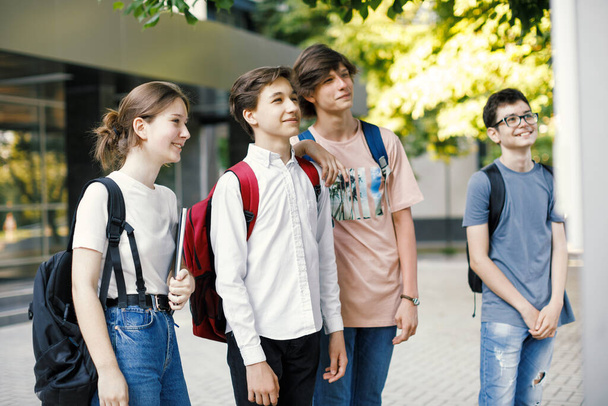 Okul arkadaşları okulun önündeki zaman çizelgesine bakıyor. - Fotoğraf, Görsel