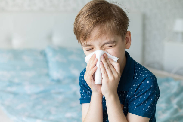 Caucasian boy suffers from a runny nose and allergic reactions to pollen. Colds viral diseases in children. - Foto, afbeelding