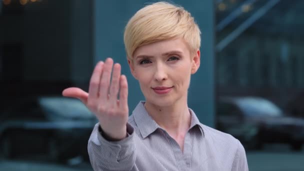 Portrait of beautiful caucasian middle aged adult 40s business woman friendly lady smiling showing gesture of invitation advice to approach herself with hand asks to come outdoors, body languages - Footage, Video