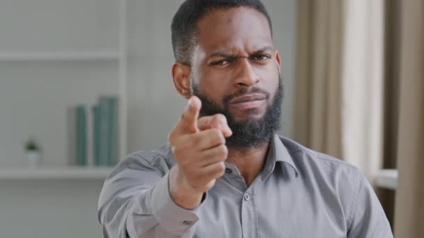 Молодой бородатый рассерженный африканский черный бизнесмен, профессиональный менеджер по персоналу, работодатель протягивает руку, показывая пальцем в камеру, осуждая угрозы работы, предупреждая обещать увольнение концепции - Кадры, видео