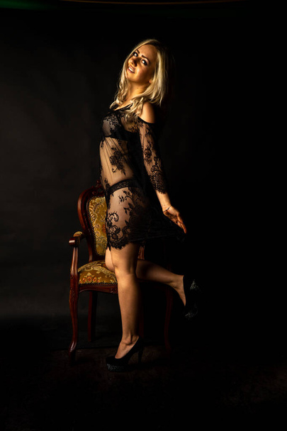 sexy schöne blonde Frau in Dessous posiert im dunklen Studio   - Foto, Bild