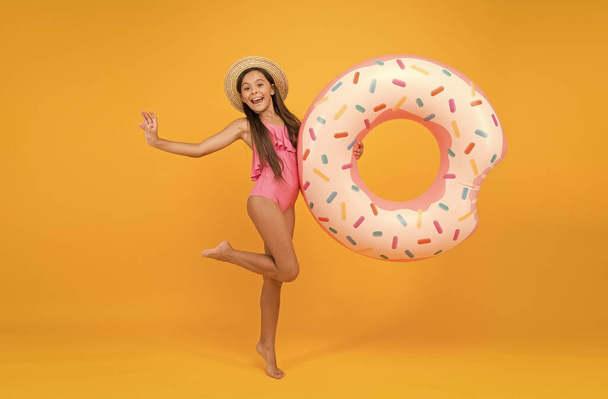 Summer resort. Recreation concept. Hotel with swimming pool. Little girl and swimming donut ring. Kid in swimsuit relaxing and having fun. Summer vacation. Cheerful kid relaxing. Relaxing at pool - Foto, Bild
