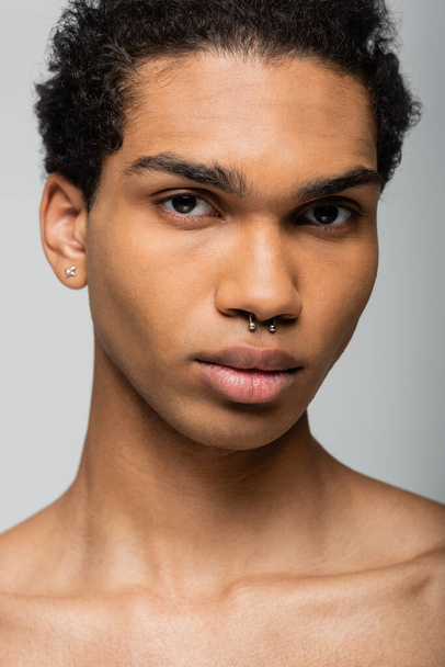 portrait of young african american man with piercing looking at camera isolated on grey, beauty concept - Fotoğraf, Görsel