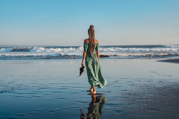 Backview of woman in dress against seascape in bali - Photo, Image