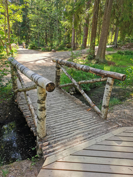 Міст зроблений повністю з берези, в скелястому природному парку Монрепос у місті Виборг в ясний літній день.. - Фото, зображення