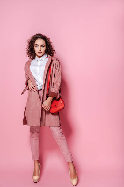 Young elegant woman in trendy pink coat. isolated studio shot - Фото, зображення