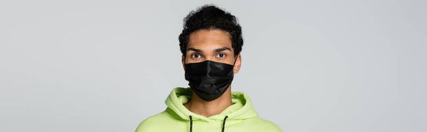 joven afroamericano hombre en negro máscara médica aislado en gris, bandera - Foto, imagen