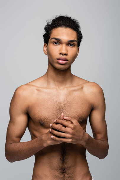 bez koszulki Afroamerykanin facet z idealny skóra patrząc w aparat odizolowany na szary, piękno koncepcja - Zdjęcie, obraz