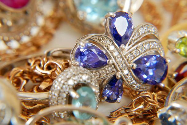 arany ékszerek gyűrűkkel, fülbevalókkal és arany lánccal, zálogház koncepció, közelkép - Fotó, kép