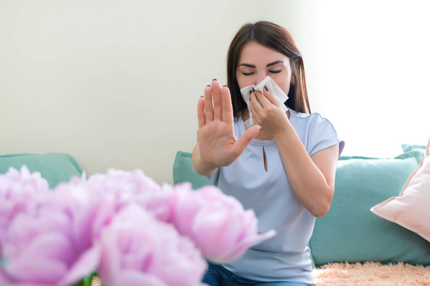 young woman sneezes from flower allergy. Pollen allergy - Zdjęcie, obraz