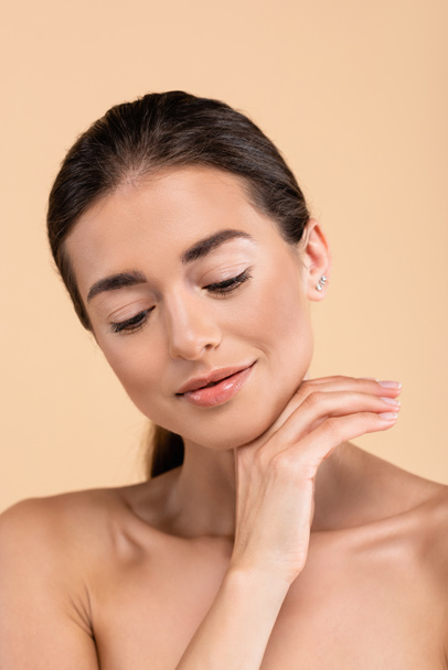 positive woman with clean skin holding hand near chin isolated on beige, beauty concept - Φωτογραφία, εικόνα