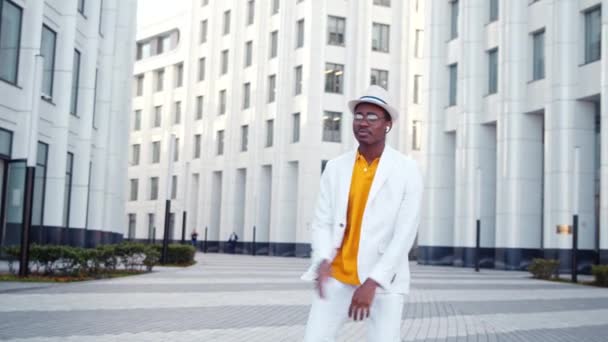 Zwarte man danser in oranje t-shirt en witte pak dansen - Video