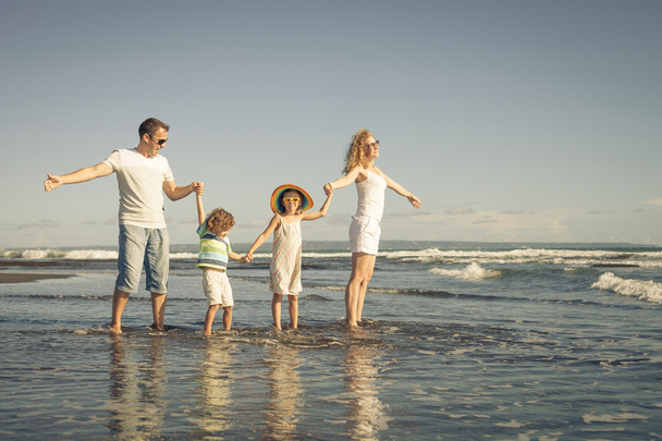 Happy family playing at the beach in the day time - 写真・画像