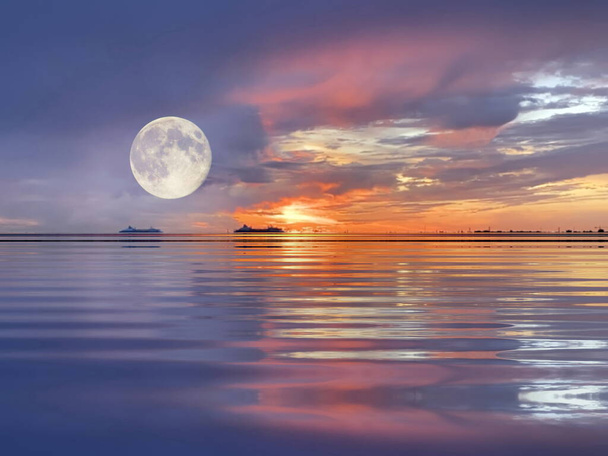 月が劇的な日没にオレンジ色の金のライラック雲が暗い空に太陽の光の反射の海の光の風景水平線のボートのバルト海の風景 - 写真・画像