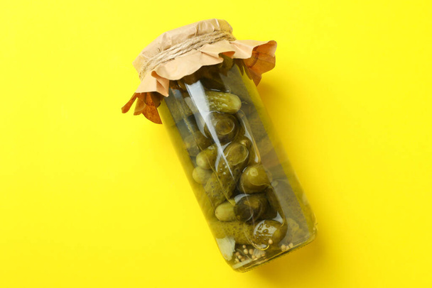 Jar with craft paper of pickles on yellow background - Foto, immagini