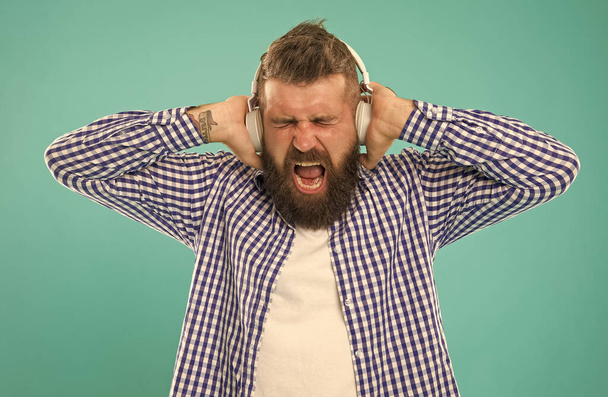 listening heavy metal. unhappy bearded man with loud sound in earphones. - Foto, immagini