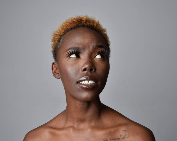 Close up cabeça e ombros retrato de uma jovem mulher africana bonita com cabelo natural. variedade de expressões faciais emotivas. Isolado em um fundo de estúdio cinza claro. - Foto, Imagem