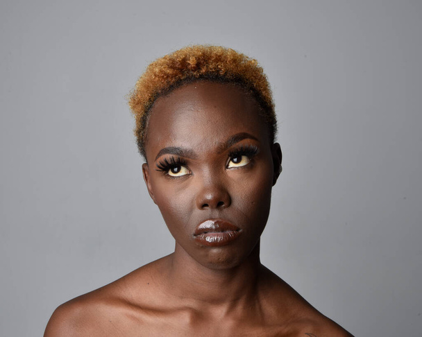 Csukd be a fejed és a vállad egy csinos fiatal afrikai nő arcképe természetes hajjal. különféle érzelmes arckifejezések. Izolált egy világosszürke stúdió háttér. - Fotó, kép