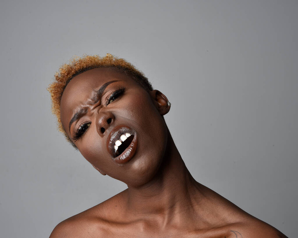 Close up cabeça e ombros retrato de uma jovem mulher africana bonita com cabelo natural. variedade de expressões faciais emotivas. Isolado em um fundo de estúdio cinza claro. - Foto, Imagem