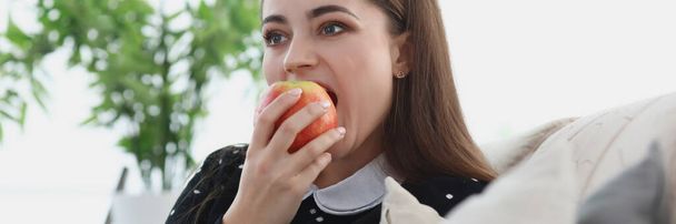Πορτρέτο της νεαρής γυναίκας δαγκώνει ένα μήλο - Φωτογραφία, εικόνα