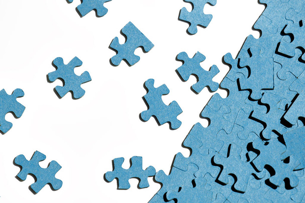jigsaw puzzles  on white background, partially assembled mosaic, many pieces of jigsaw puzzles, the concept of laborious work, finding the right shape, training attention and perseverance - Photo, image