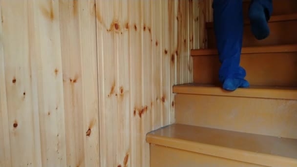 Ein Mann steigt langsam eine Holztreppe hinauf und dann hinunter - Filmmaterial, Video