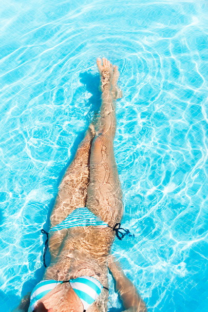 Тело молодой женщины в кристально чистой воде
 - Фото, изображение