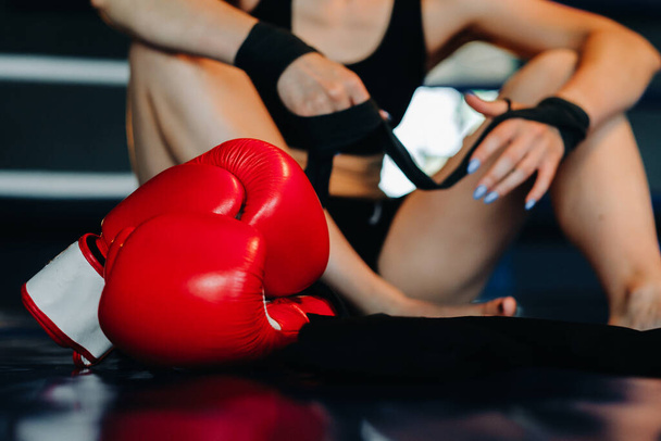 Close-up of red boxing gloves on the floor of a blue boxing ring. - Foto, Bild