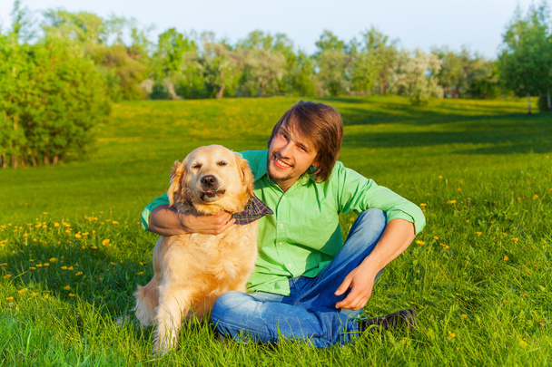 χαμογελά πατέρα με το σκυλί κάθεται στο έδαφος στο πάρκο - Φωτογραφία, εικόνα