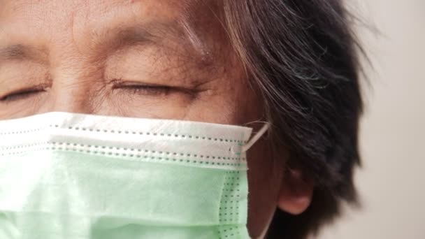 Koronavirüsü (Covid-19) önlemek için Asyalı yaşlı kadının yüzüne yakından bakın. Yaşlı gözler stresli, endişeli, hasta olmaktan korkuyor.. - Video, Çekim