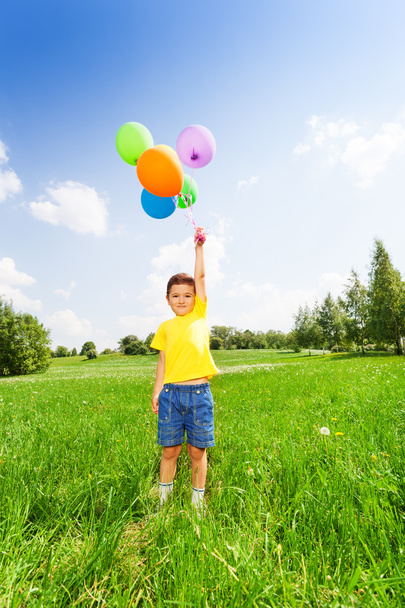 Boy in yellow T-shirt standing with balloons - Foto, immagini