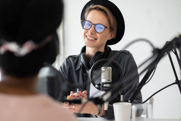 Young and confident European woman recording a podcast in a recording studio - Φωτογραφία, εικόνα