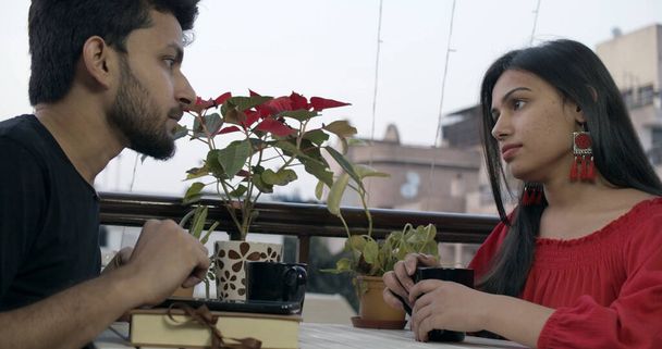 A young Indian couple talking while on a date in a restaurant - Фото, изображение