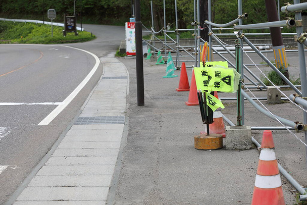 bandeiras pedestres amarelas, com uma passarela de rua pronta para uso no lago inawashiro. 'Crossing' está escrito nele em japonês. - Foto, Imagem