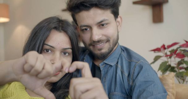 A young Indian couple showing heart with their hands - Foto, imagen