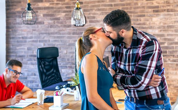 Businesswoman and businessman kissing in office - Fotoğraf, Görsel
