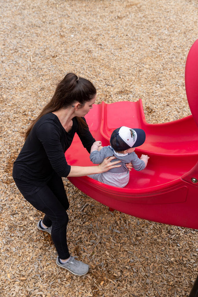Mother and baby boy playing at the local playground. - Photo, Image