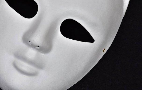 Biała maska z pustymi oczodołami na czarnym tle - Zdjęcie, obraz