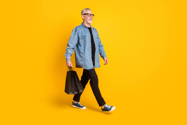 Full body profile photo of fashionable granddad go with bags wear blazer pants shoes isolated on yellow color background - Foto, Imagem