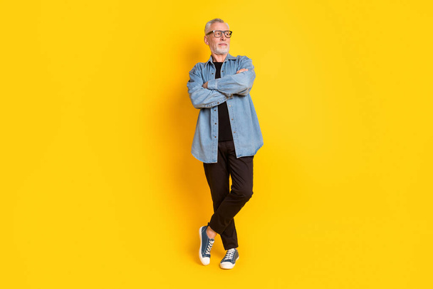 Full length photo of trend grandpa crossed arms look empty space wear eyewear jacket pants isolated on yellow background - Fotografie, Obrázek