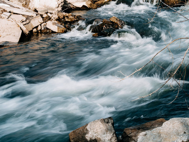 the flow of a stormy river over rocks, clear blue water - Foto, Imagem