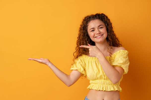 Young cheerful girl smiling point finger to copy space - Foto, Bild