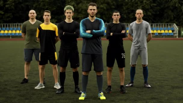 Jugadores del equipo de fútbol posan después de entrenar en el estadio de la ciudad con los brazos cruzados sobre el pecho - Imágenes, Vídeo
