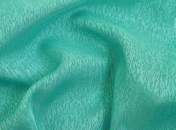 Smaragdfarbener, zerknüllter Stoffhintergrund, leichte, luftige, transparente Textur. Stoff Hintergrund für Design. - Foto, Bild